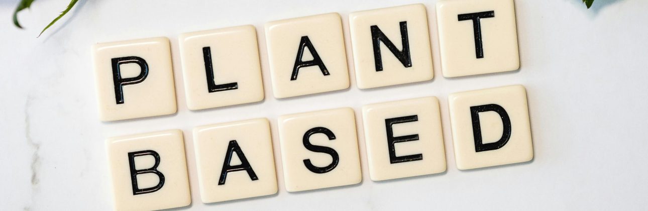 pexels-photo-3669638-3669638 Scrabble tiles spelling 'Plant Based' surrounded by green leaves, promoting a vegan lifestyle.